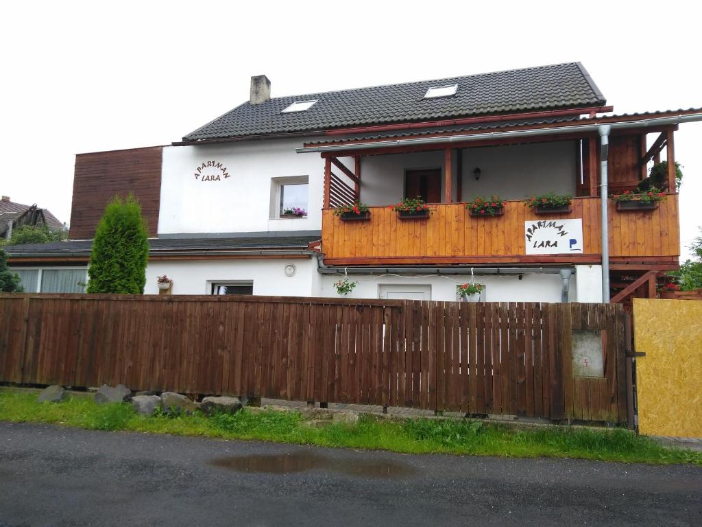 a house with a wooden fence in front of it at apartman.lara in Děčín