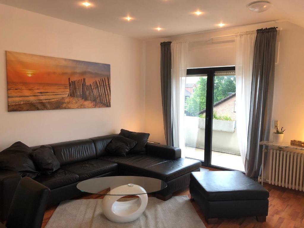 uma sala de estar com um sofá preto e uma janela em Ferienwohnung Katja em Bad Lippspringe