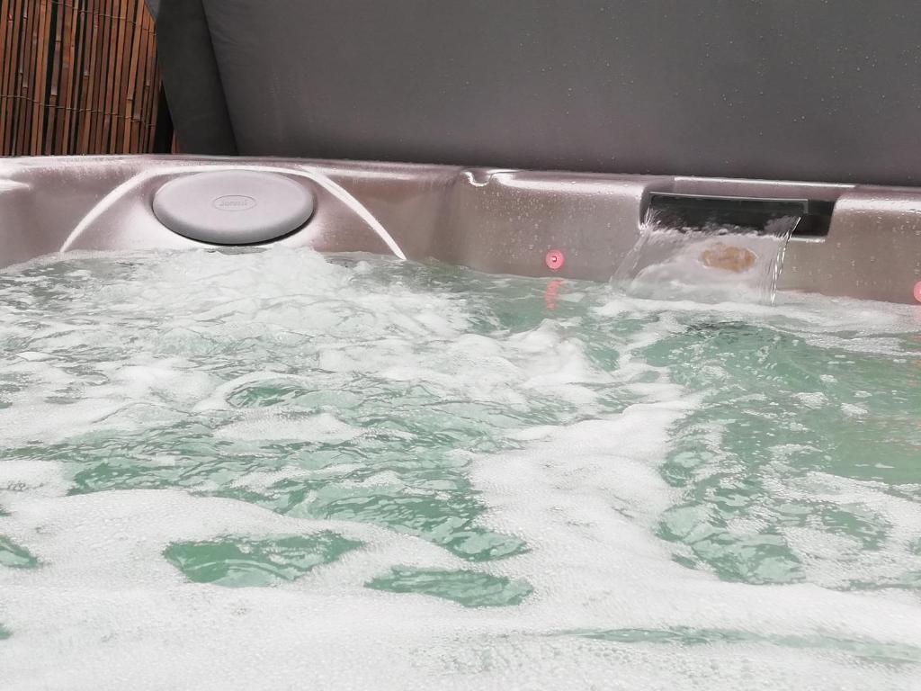eine Badewanne mit grünem und weißem Wasser in der Unterkunft Un Spa au Canyon in Freyming