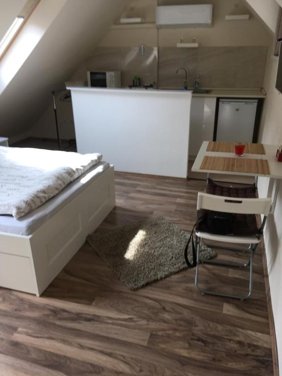 um quarto loft com uma cama e uma mesa em MiNa apartman em Eger