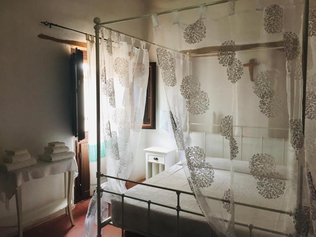 a bedroom with a bed with a net curtain at Il Portico Guesthouse in Muravera