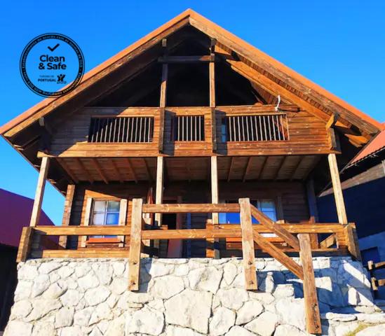 a large wooden building on top of a stone wall at Chalet 52, Serra da Estrela a perder de vista in Penhas da Saúde