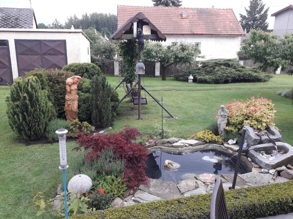 a garden with a pond and a statue in a yard at U lesa in Bohutín
