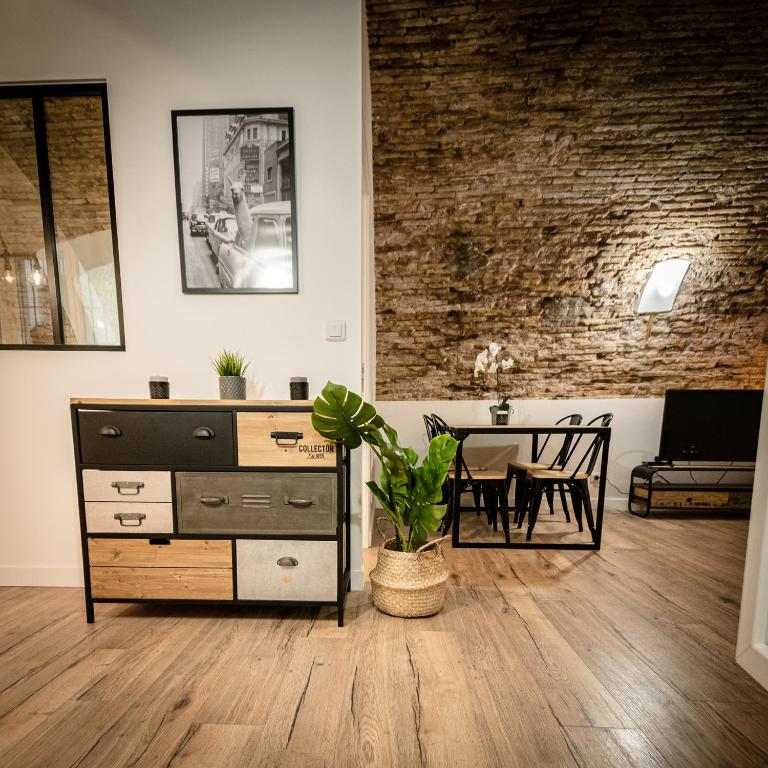 - un salon avec une commode et une table à manger dans l'établissement Les Voûtes du Vieux-Port, à Marseille