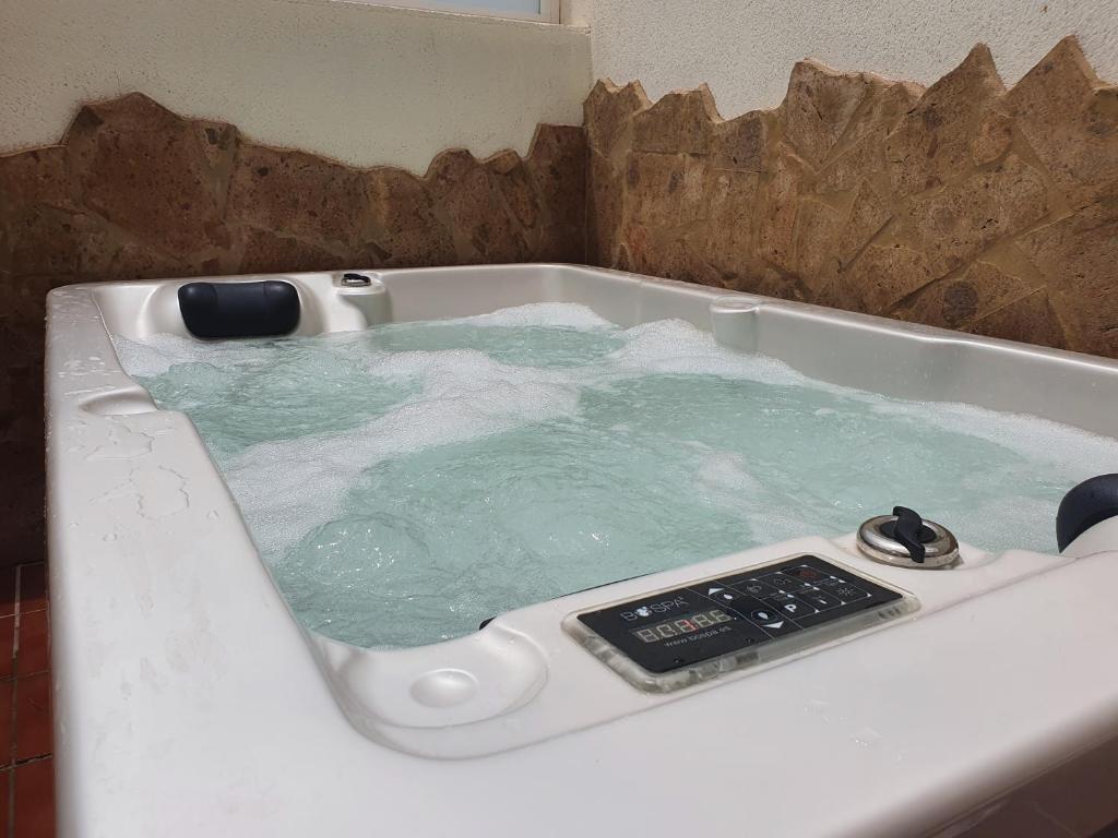 uma banheira cheia de água com um controlo remoto em Apartamento El Valle Puerto Rico con Jacuzzi em Porto Rico