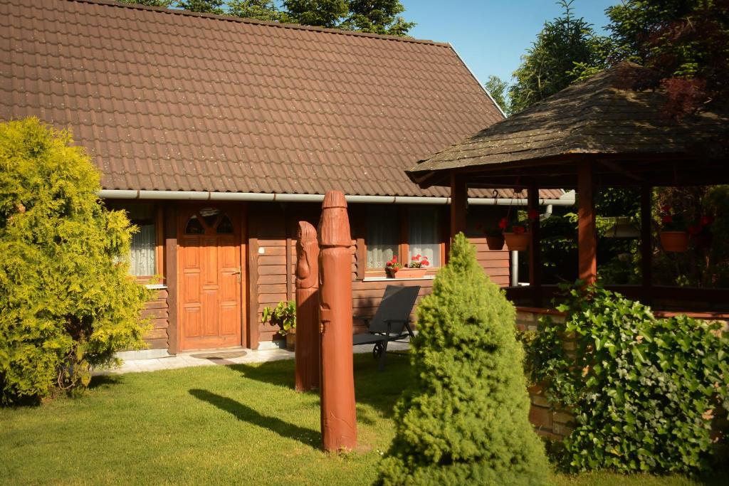 a house with a bench and a gazebo at Családbarát Faház in Kehidakustány