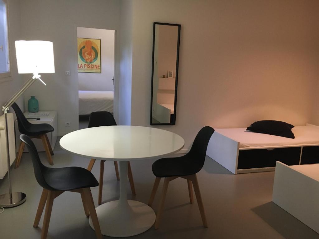 ラ・シオタにあるT2 L'Escapadeのベッド、テーブル、椅子が備わる小さな客室です。