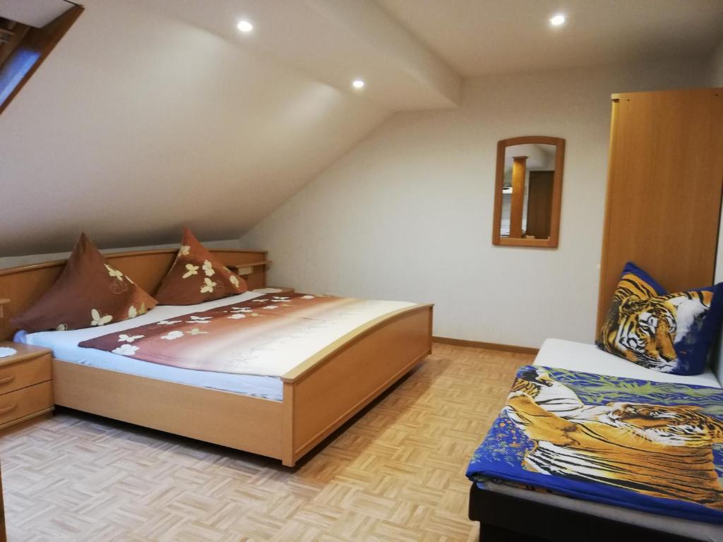 a bedroom with two beds and a mirror at Wein-und Gästehaus Alfons Bollig in Trittenheim
