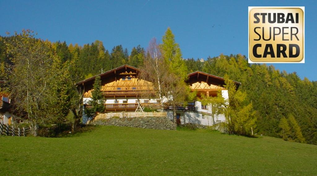 a house in a field with a sign that reads student super card at Pfurtschell in Neustift im Stubaital
