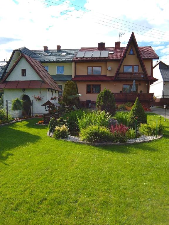 a large house with a yard with green grass at Noclegi Barbara Pietraszek in Krempachy