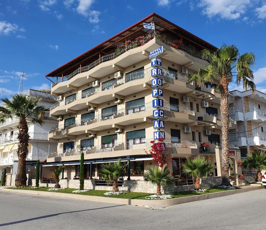 a large hotel with palm trees in front of it at Tropicana in Paralia Katerinis