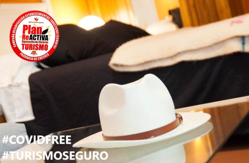 un sombrero vaquero blanco sentado en la parte superior de una mesa en Apartamentos de la Parte Antigua de Cáceres, en Cáceres