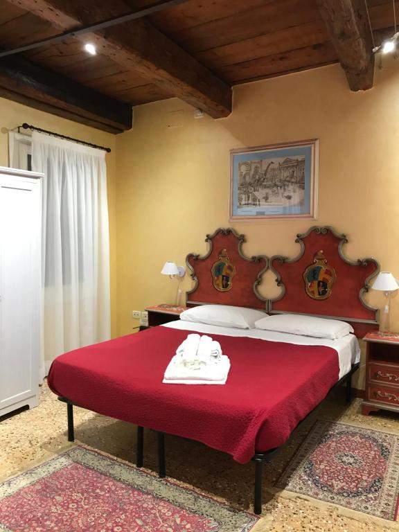 威尼斯的住宿－聖薩沃羅公寓，一间卧室配有红色的床和红色毯子