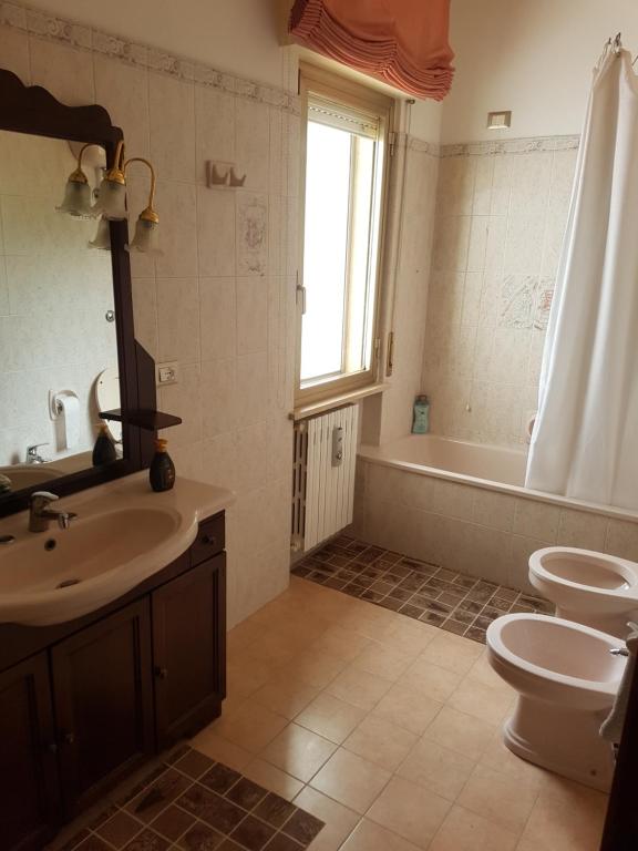 een badkamer met een wastafel, een toilet en een bad bij Appartamento La finestra sul mare in Madonna della Pace