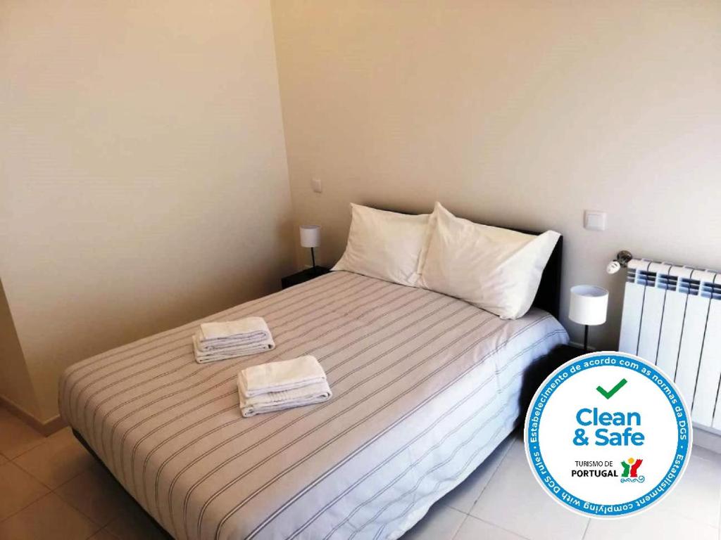 a bedroom with a bed with two towels on it at Cândido Reis Apartments in Lagos