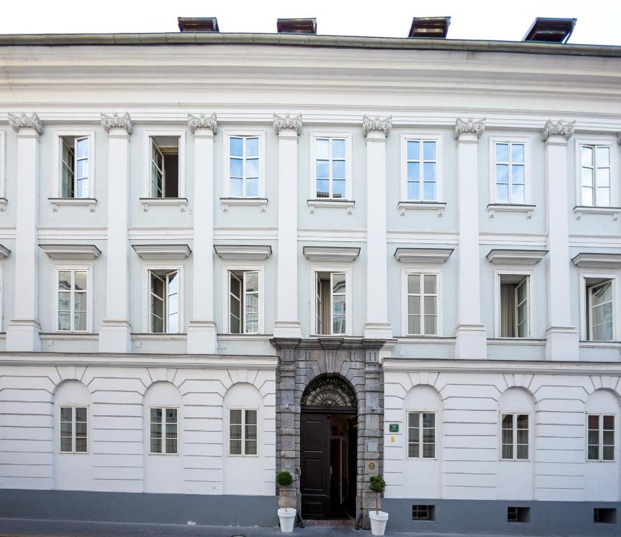 ein weißes Gebäude mit einer Tür davor in der Unterkunft Antiq Palace - Historic Hotels of Europe in Ljubljana