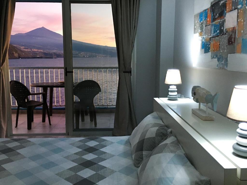 a bedroom with a balcony with a view of a mountain at Mesa del Mar Sunset Dream vacational rental home in Puerto de la Madera