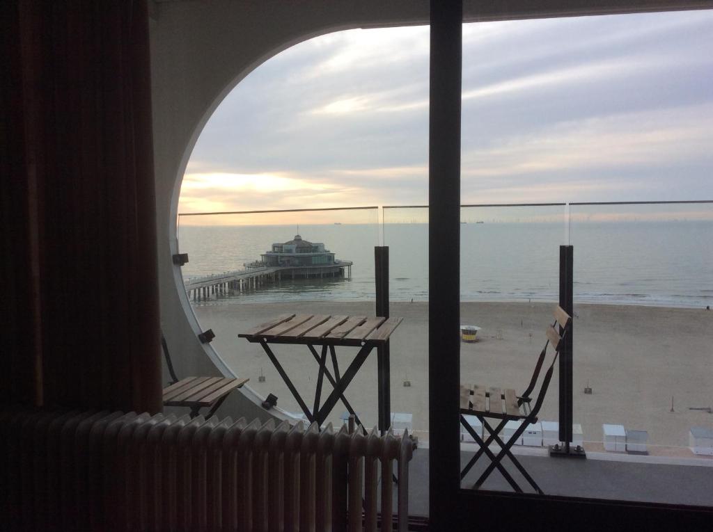 a view of the beach from a room with a table and chairs at Isola Bella in Blankenberge