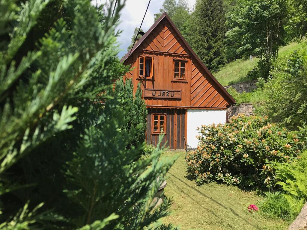 een klein houten huis in het midden van een veld bij Chalupa U Jezu in Tanvald