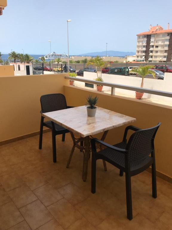 een tafel en stoelen op een balkon met uitzicht bij Apt Los Cristianos Beach 1 in Los Cristianos