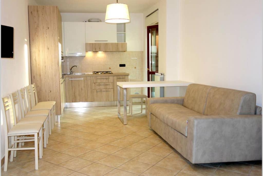 uma sala de estar com um sofá e uma cozinha em Appartamento Lidarno em Lidarno