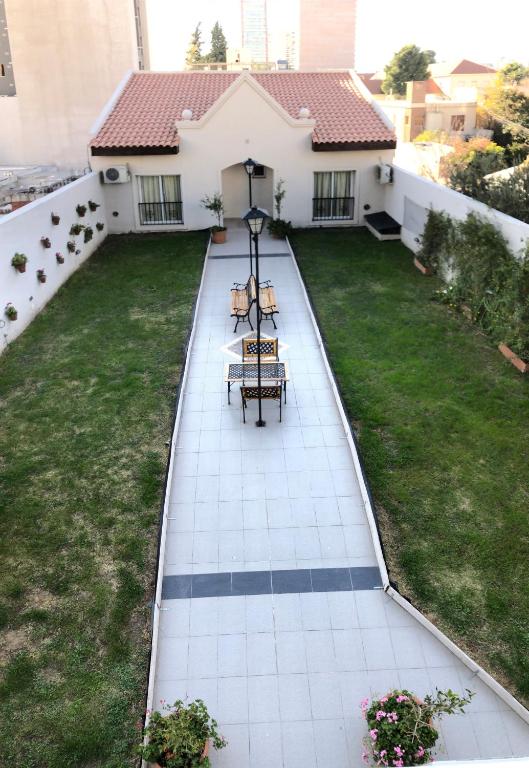 a patio with two chairs and a table on a house at Apart Hotel Granada in Neuquén