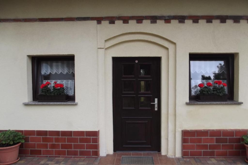 uma casa com duas janelas e uma porta com flores em Ferienwohnung Wiesenblick em Burg