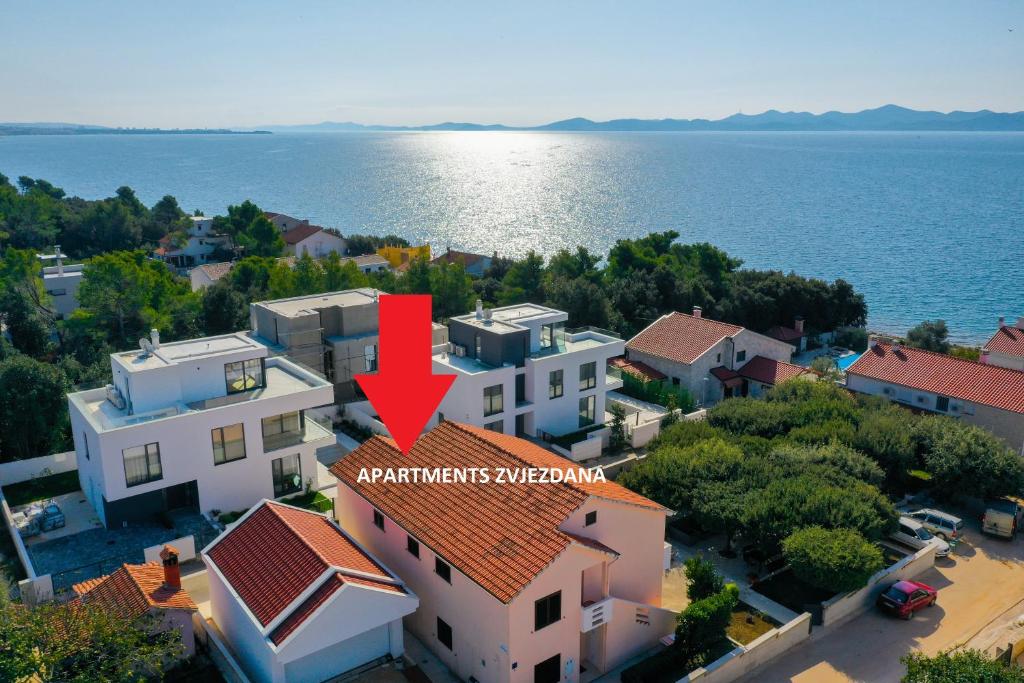 een luchtfoto van een huis met een rode pijl erop bij Apartments Zvjezdana in Petrcane