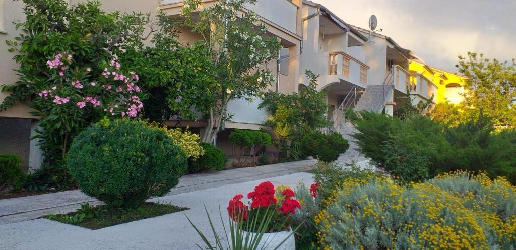 a garden with flowers and plants in front of a building at Apartments Golić in Biograd na Moru