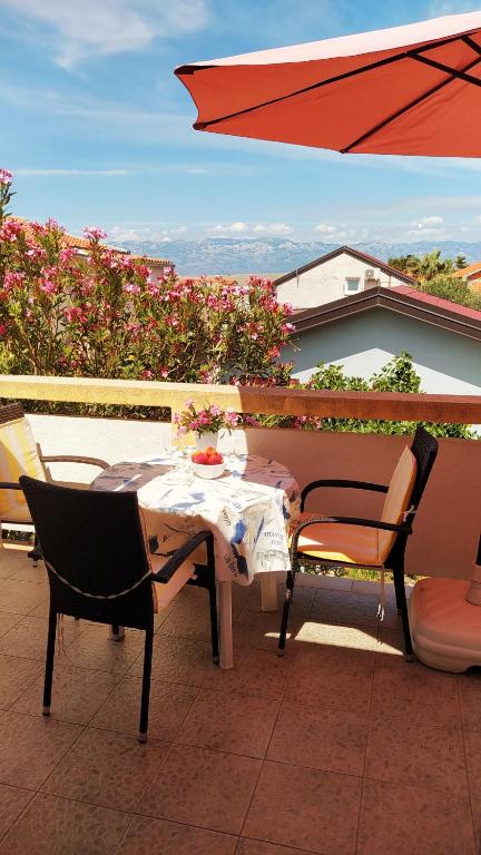 stół i krzesła na patio z parasolem w obiekcie Apartmani Lučica 2 w mieście Vir