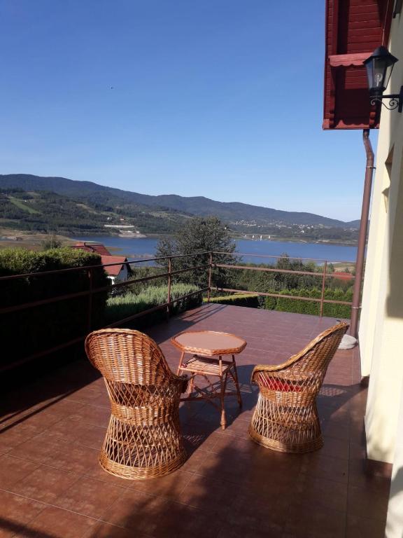 a patio with two chairs and a table on a balcony at Dom nad Jeziorem in Mucharz