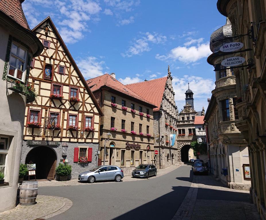 uma rua da cidade com edifícios e carros estacionados na rua em Löwen Hotel & Restaurant em Marktbreit