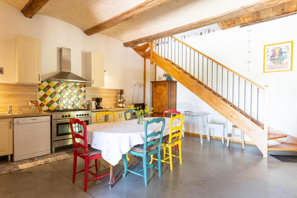 una cocina con una mesa con sillas y una escalera en Mas du Cres Gîte, en Galargues
