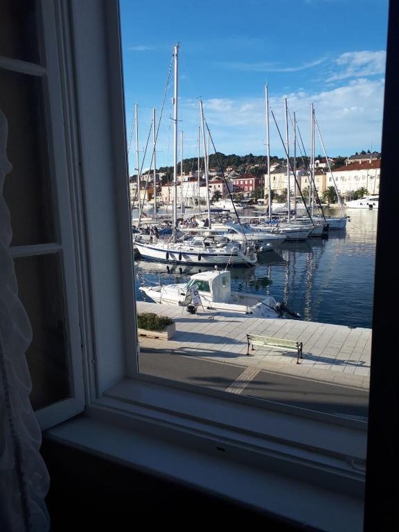 a window with a view of boats in a marina at Apartments Petra 23 in Mali Lošinj