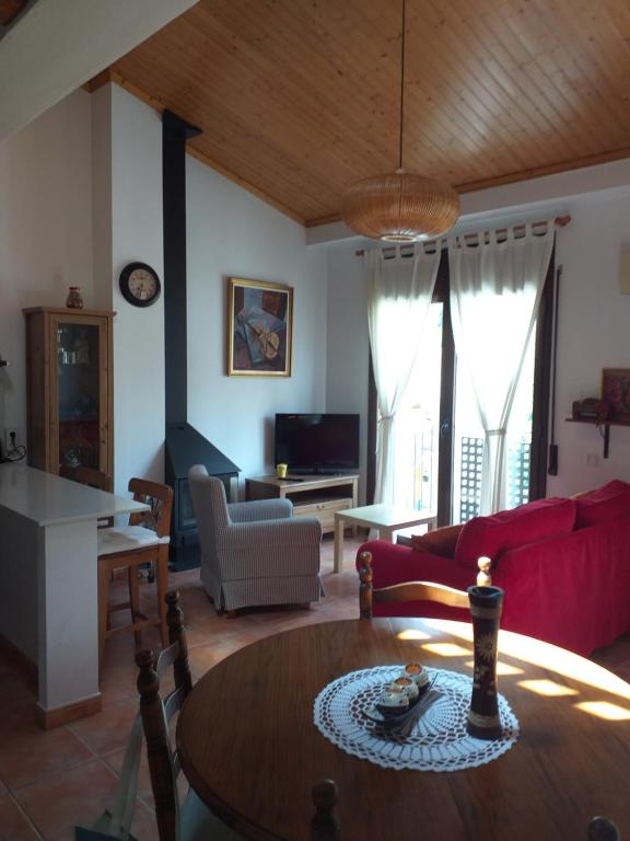 a living room with a red couch and a table at Apartament FRESER II in Ribes de Freser