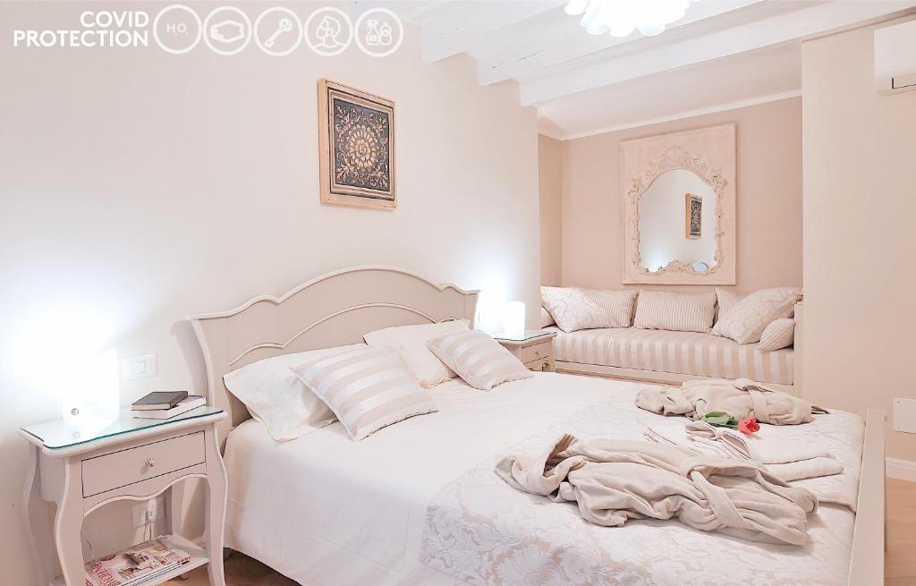 ヴェローナにあるBoutique Apartments Veronaの白いベッドルーム(ベッド1台、ソファ付)
