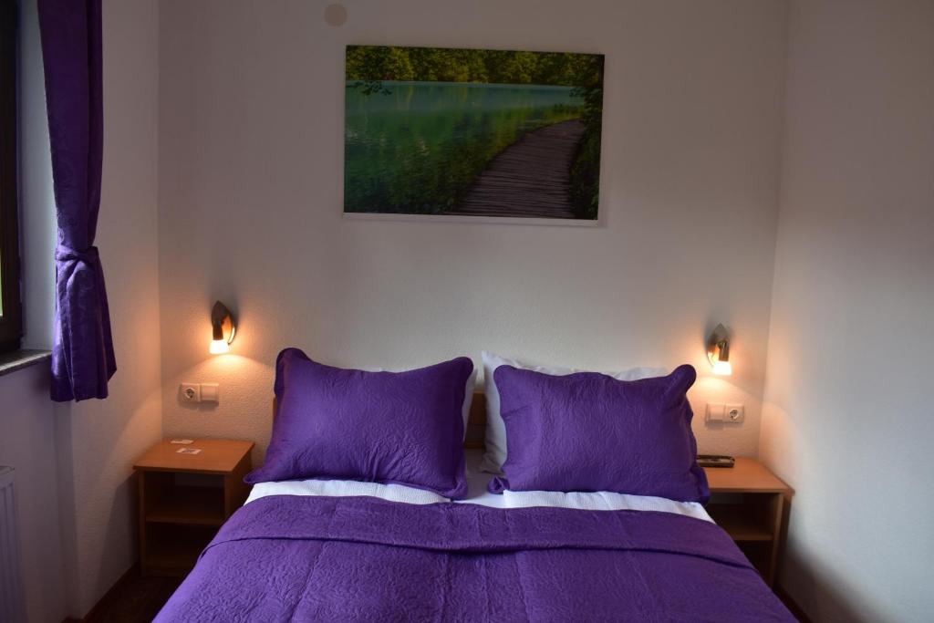 1 dormitorio con 1 cama de color púrpura y 2 mesitas de noche en Plitvice House Rosha, en Lagos de Plitvice