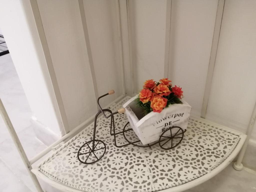 un vaso di fiori su un tavolo con una bicicletta con fiori di I colori di Iglesias a Iglesias