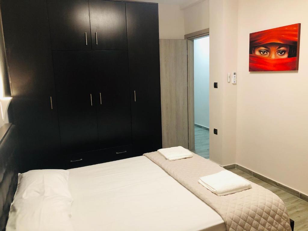 um quarto com uma cama e um armário preto em Angela Apartments em Fanárion