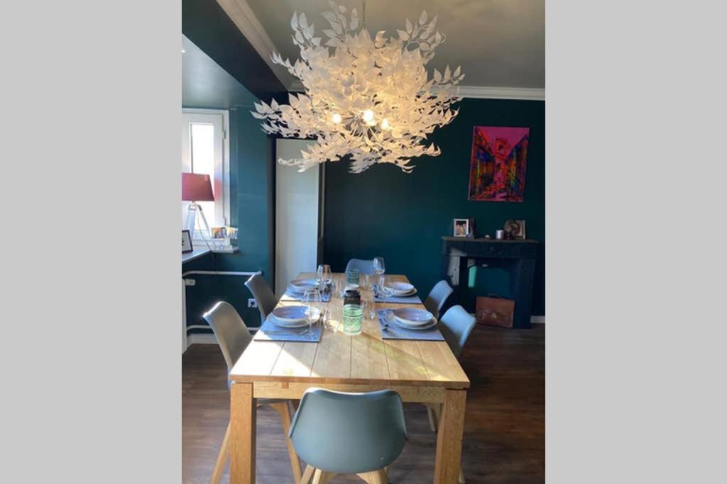 uma sala de jantar com uma mesa com cadeiras e um lustre em Fördestyle, Stilvolle Wohnung in zentraler Lage em Kiel