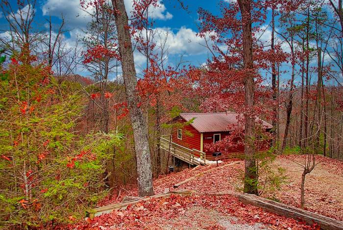 een rood huis midden in een bos bij Mountain Memories in Gatlinburg