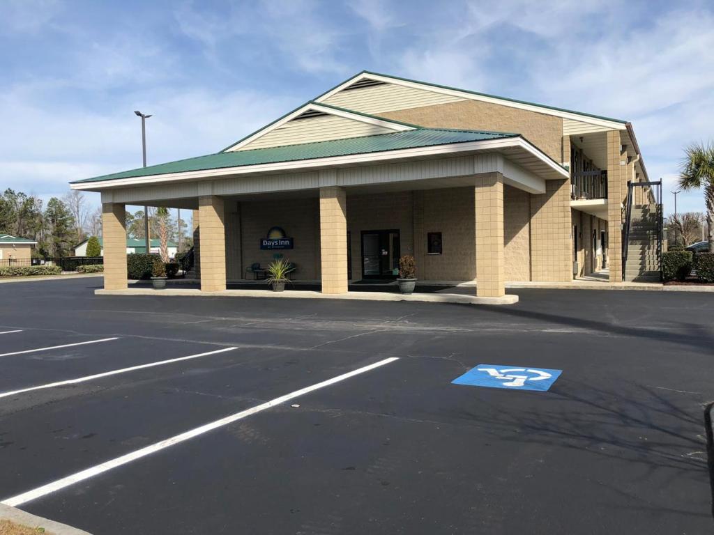 een tankstation met een bord op straat bij Days Inn by Wyndham Cape Carteret in Cape Carteret