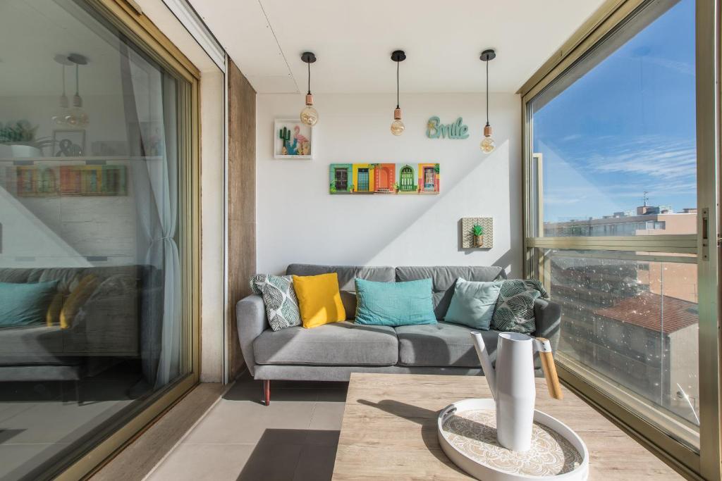 Una sala de estar con un sofá y una ventana grande. en LB Vacation Rentals I Admire Panoramic Ocean Views Through Walls of Windows, en Cannes