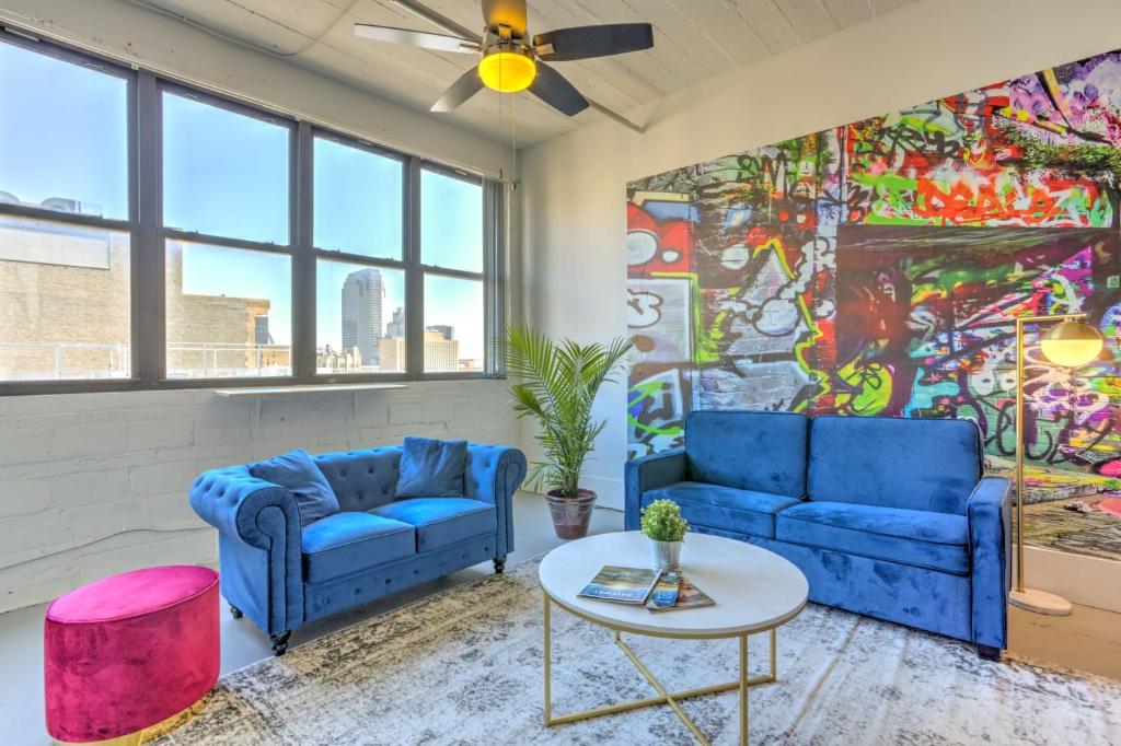 a living room with two blue couches and a table at Ultra Chic Loft walk to CityMu/Aquarium/ConvnCntr in Saint Louis