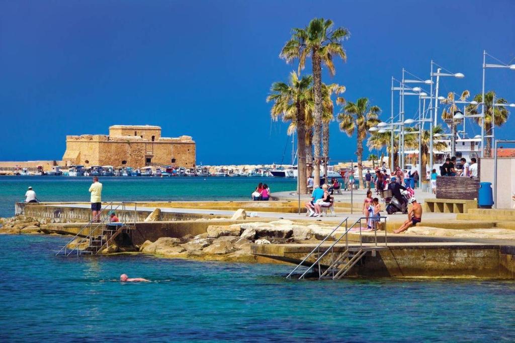 un grupo de personas en el agua en una playa en Poseidon 51 - Beachfront Two Bedroom Apartment, en Pafos