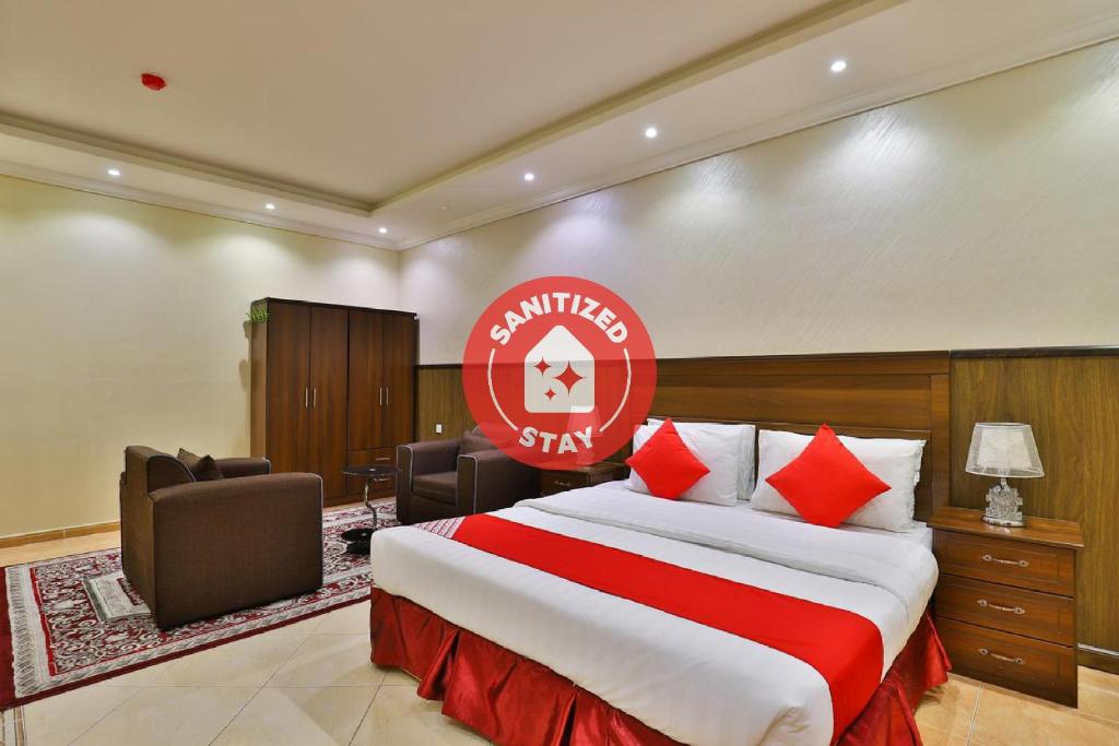 a hotel room with a bed and a red sign at OYO 273 Star Yanbu Hotel Suites in Yanbu