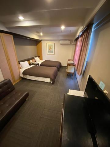 Postel nebo postele na pokoji v ubytování Hotel Yutaka Wing