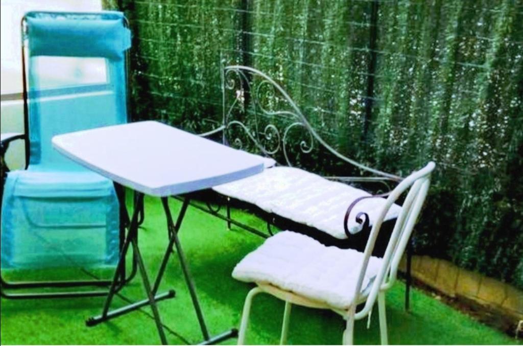 une table, deux chaises, une table et une chaise dans l'établissement NICE VIEW Jolie Studio avec Jardin, à Nice