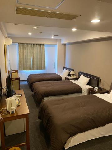 Postel nebo postele na pokoji v ubytování Hotel Yutaka Wing