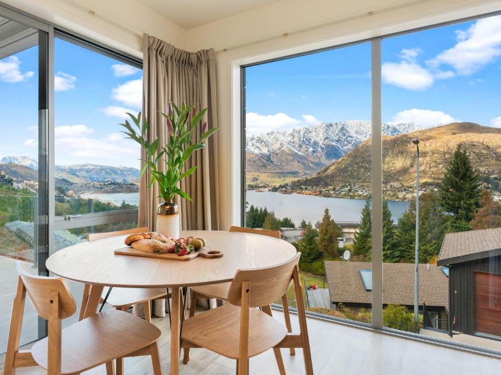 uma sala de jantar com mesa e cadeiras e uma grande janela em Quaint Sanctuary on Quartz em Queenstown